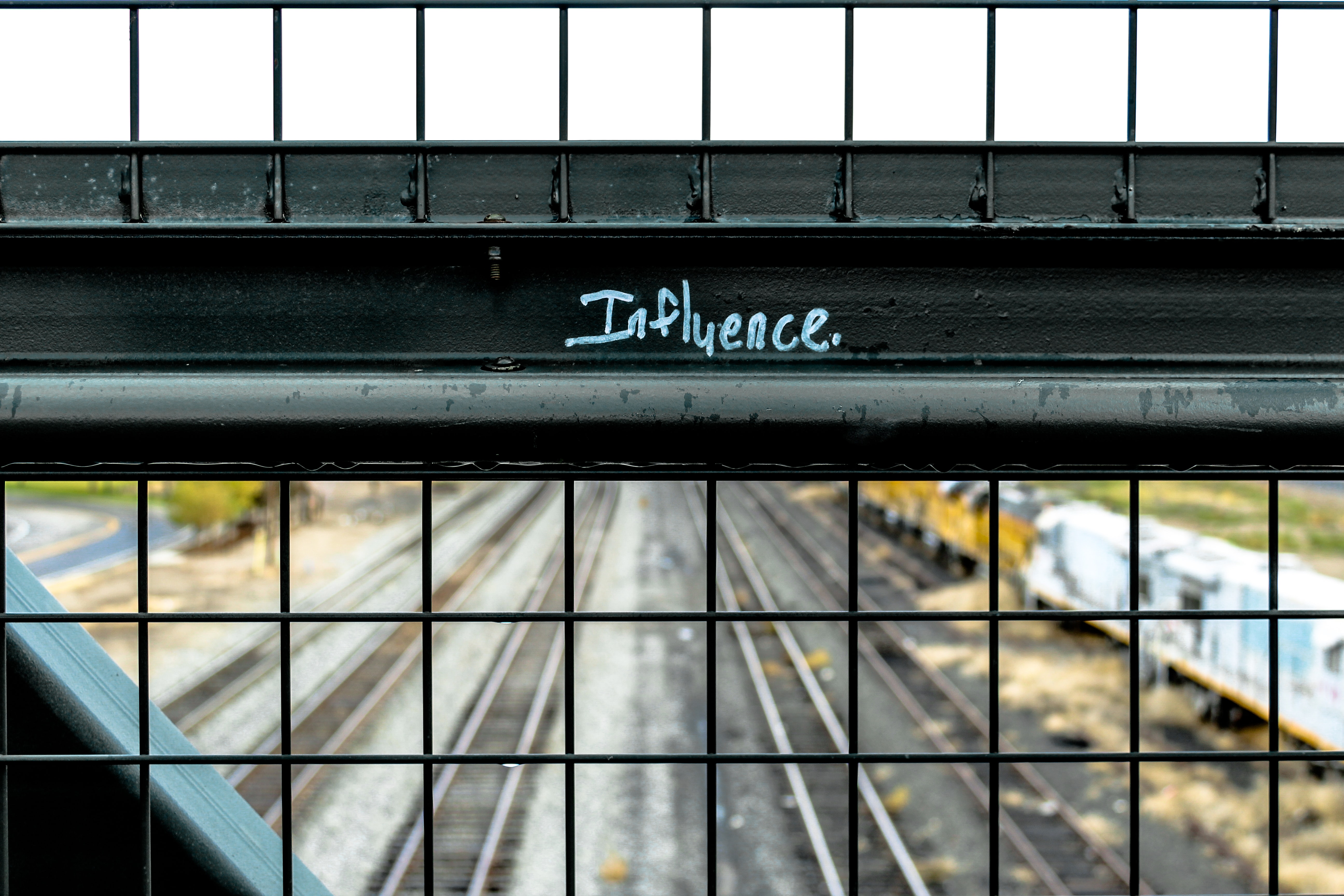 The word influence written on a iron railing